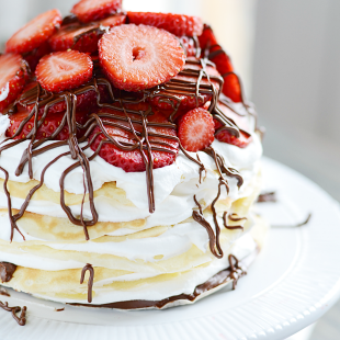 Layers of crepes filled with Nutella, cream, and strawberries. This Nutella Crepe Cake is delicious and pretty easy to make too!