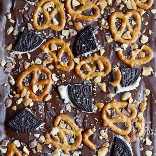 Easy chocolate bark topped with pretzels, Oreos, peanuts, almonds, and sea salt.